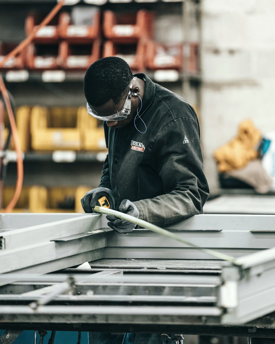 Zwei Personen vermessen einen Metallrahmen in der Werkstatt